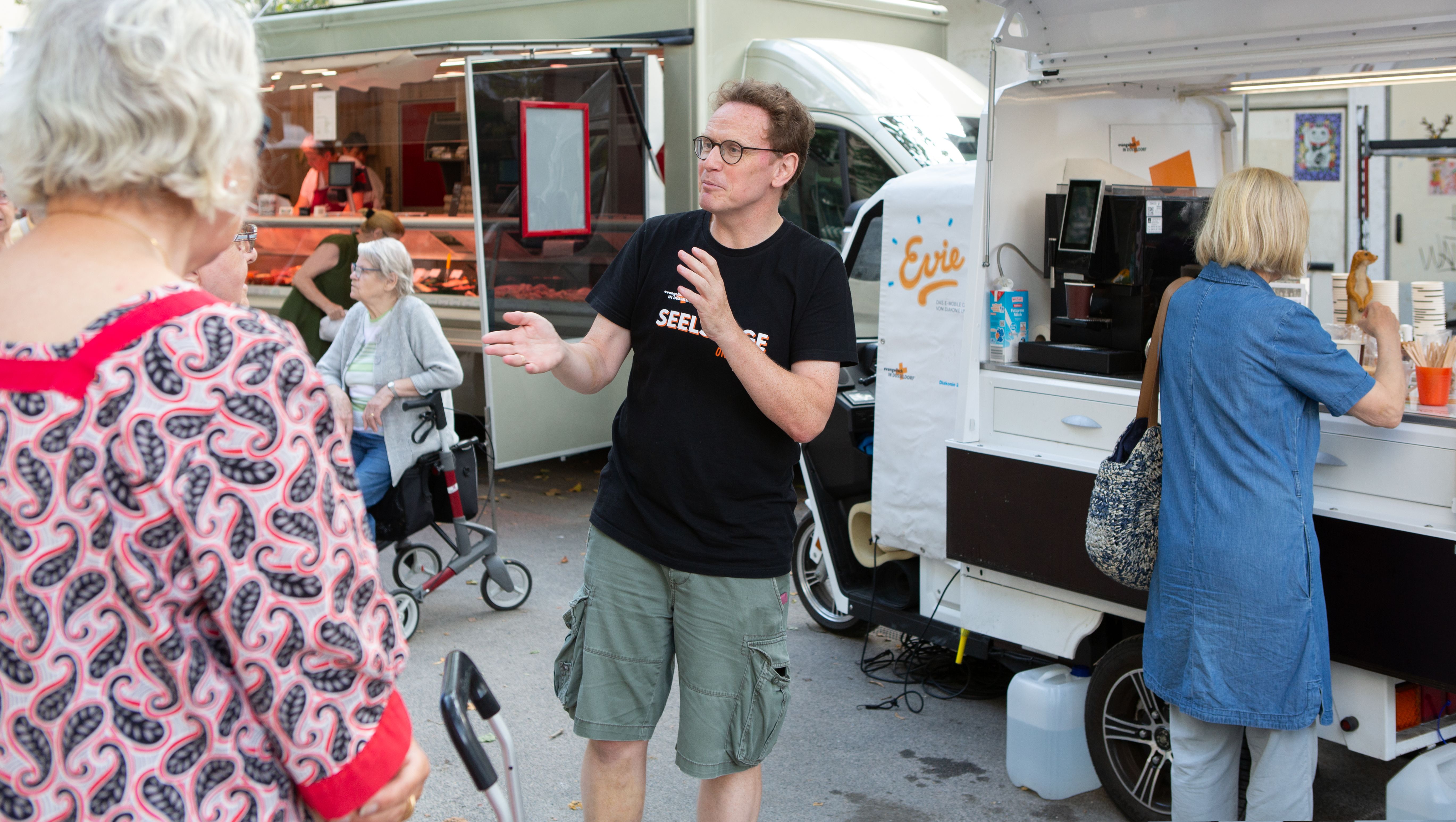 Seelsorger Peter Krogull im Gespräch vor dem Kaffeemobil Evie