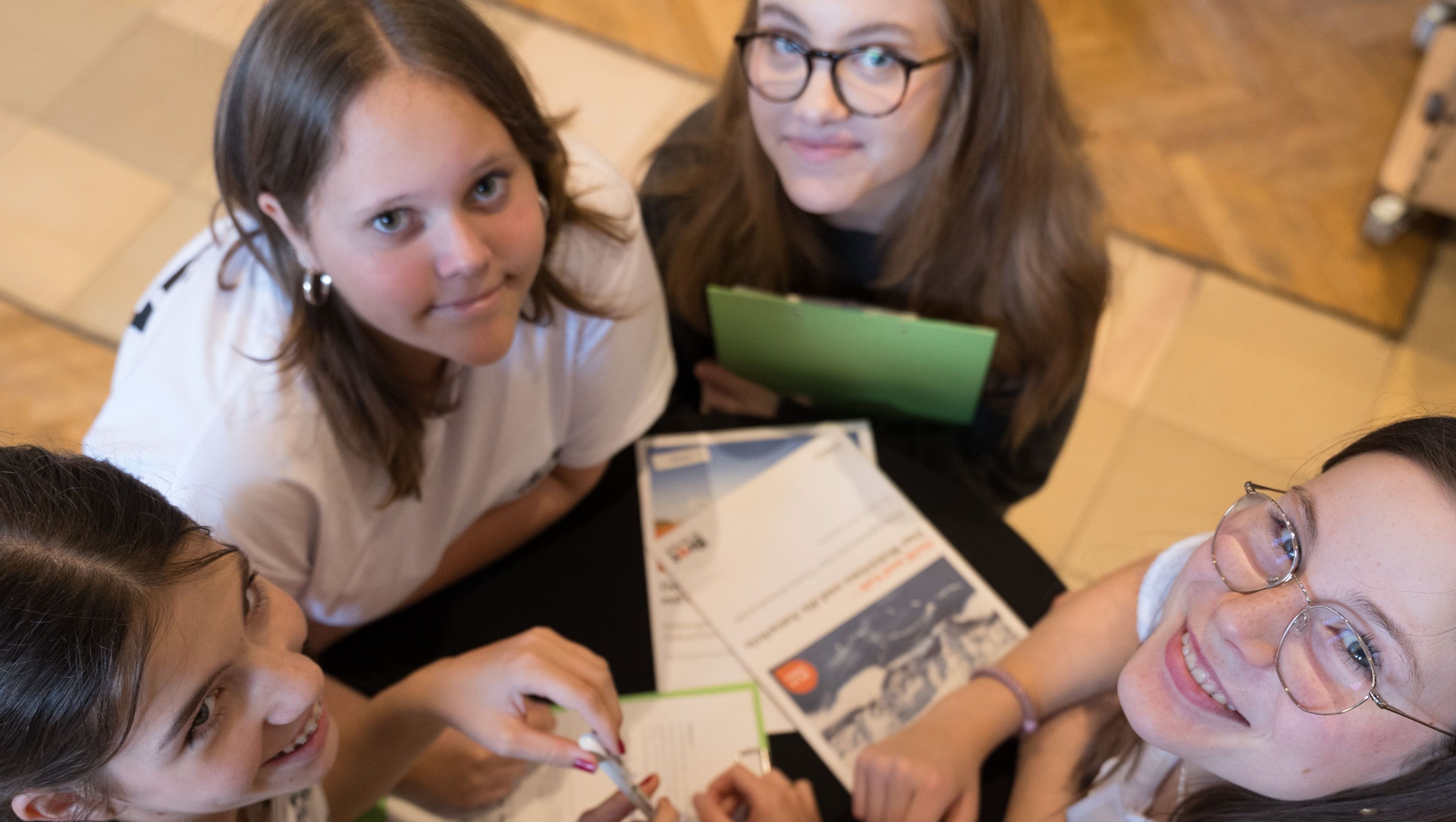 Konfirmanden und Konfirmandinnen im Kreis schauen nach oben in die Kamera; Foto: Lars Schütt