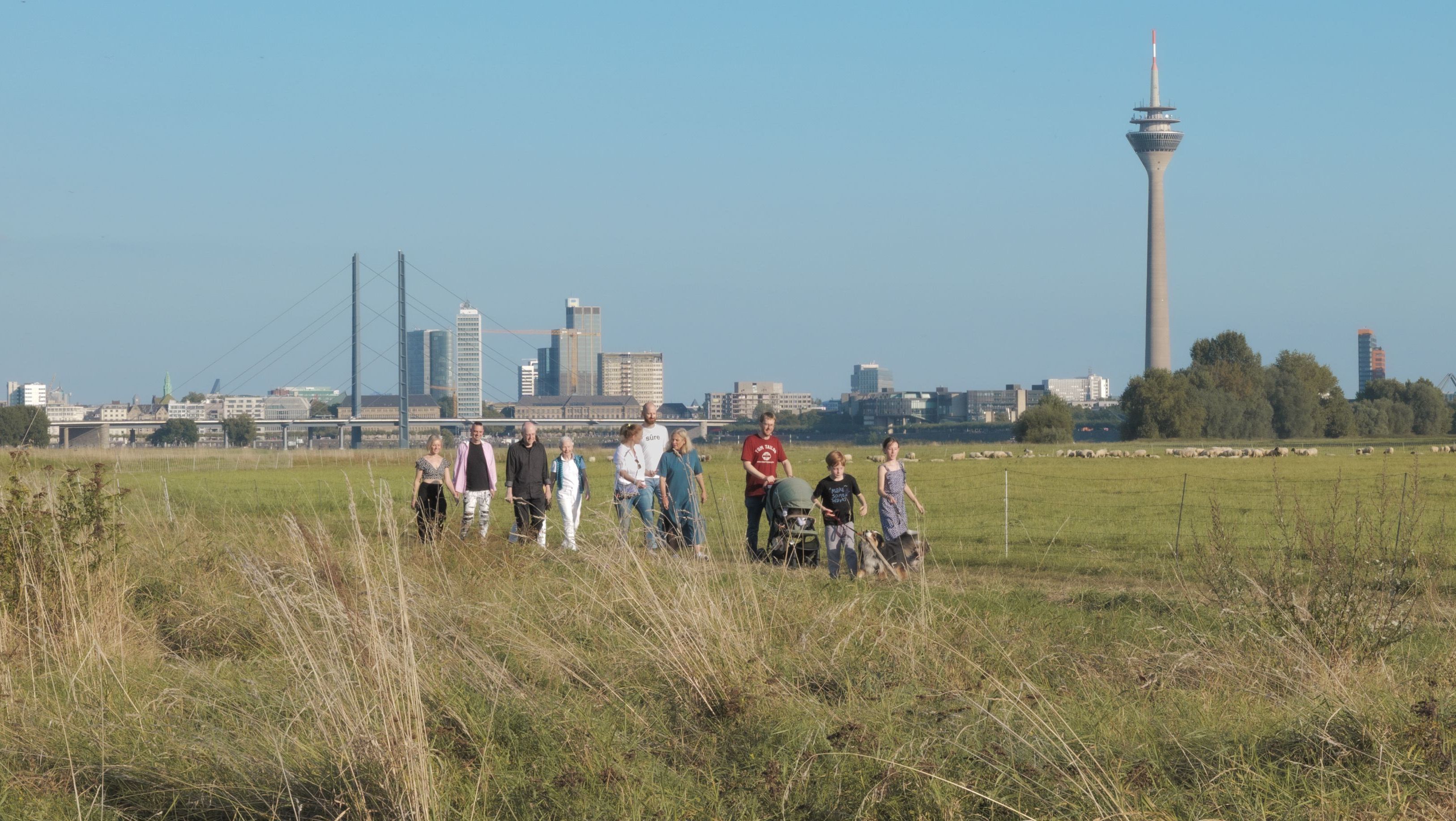 Junge und alte Menschen in unterschiedlichen Lebenssituationen gehen am Rhein spazieren